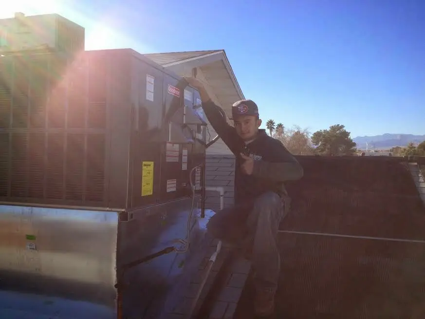 HVAC technician performing Heat Pump Repair on a rooftop unit in Smithville